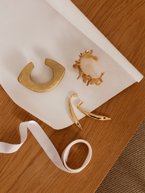 Elegant jewelry accessories including cuffs and earrings with decorative ribbon for luxury gifting