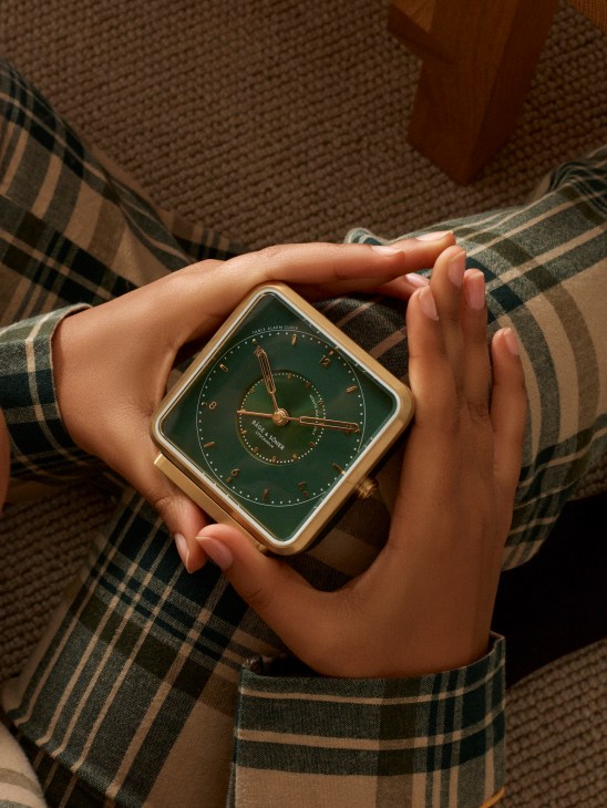 Luxury pajamas laid out with elegant clock, showcasing comfortable sleepwear and timepiece for home