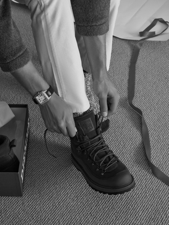 Outdoor menswear ensemble with jacket, boots, watch and accessories for weather-resistant styling