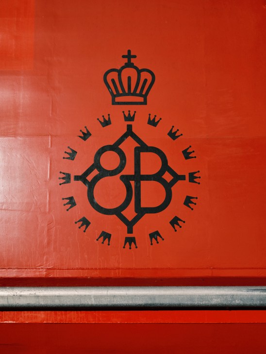 Red Queen Beetle ferry branding and logo design featuring a crown and QB monogram on red hull