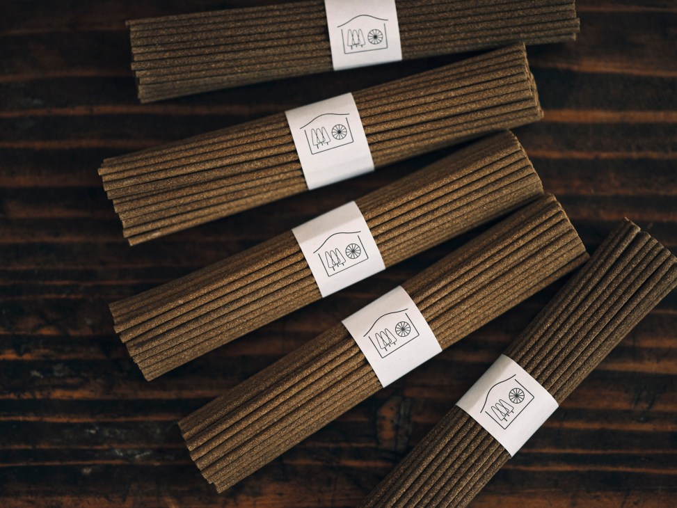 Handmade incense sticks by Baba Suishaba arranged in neat rows with white paper bands featuring house logos