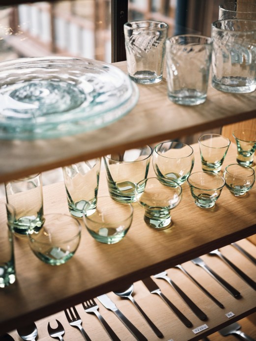 Clear glass bowls, cups and vessels displayed on wooden shelves at Unagi no Nedoko craft shop