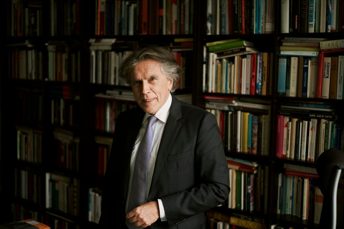 Emil Brix, director of the Vienna School of International Studies, standing in front of bookshelves