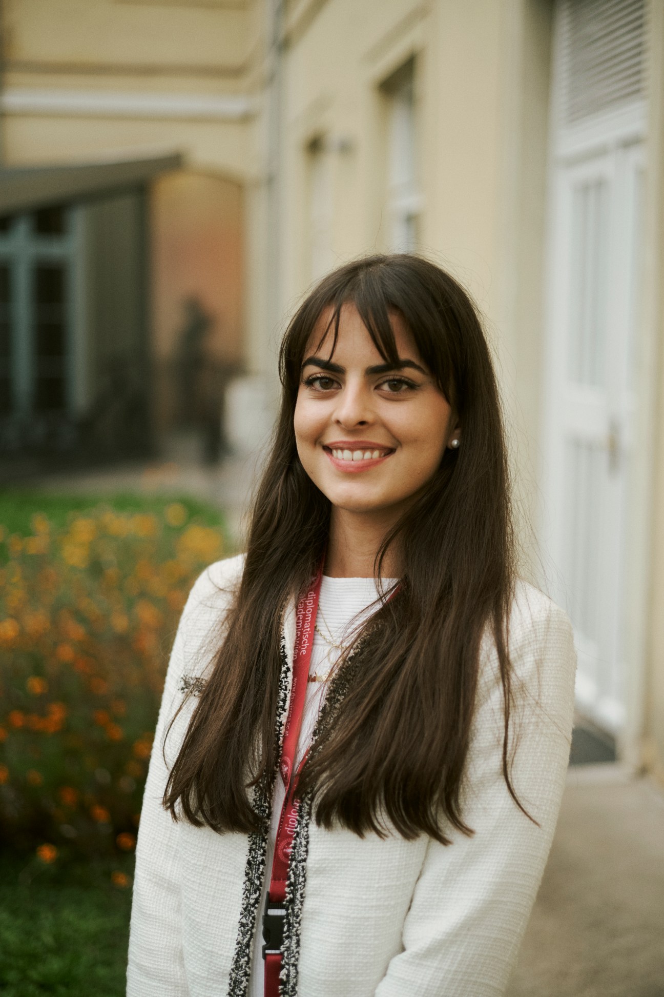 Anna-Sophie Faivre standing in an academy hallway wearing a white sweater and red lanyard