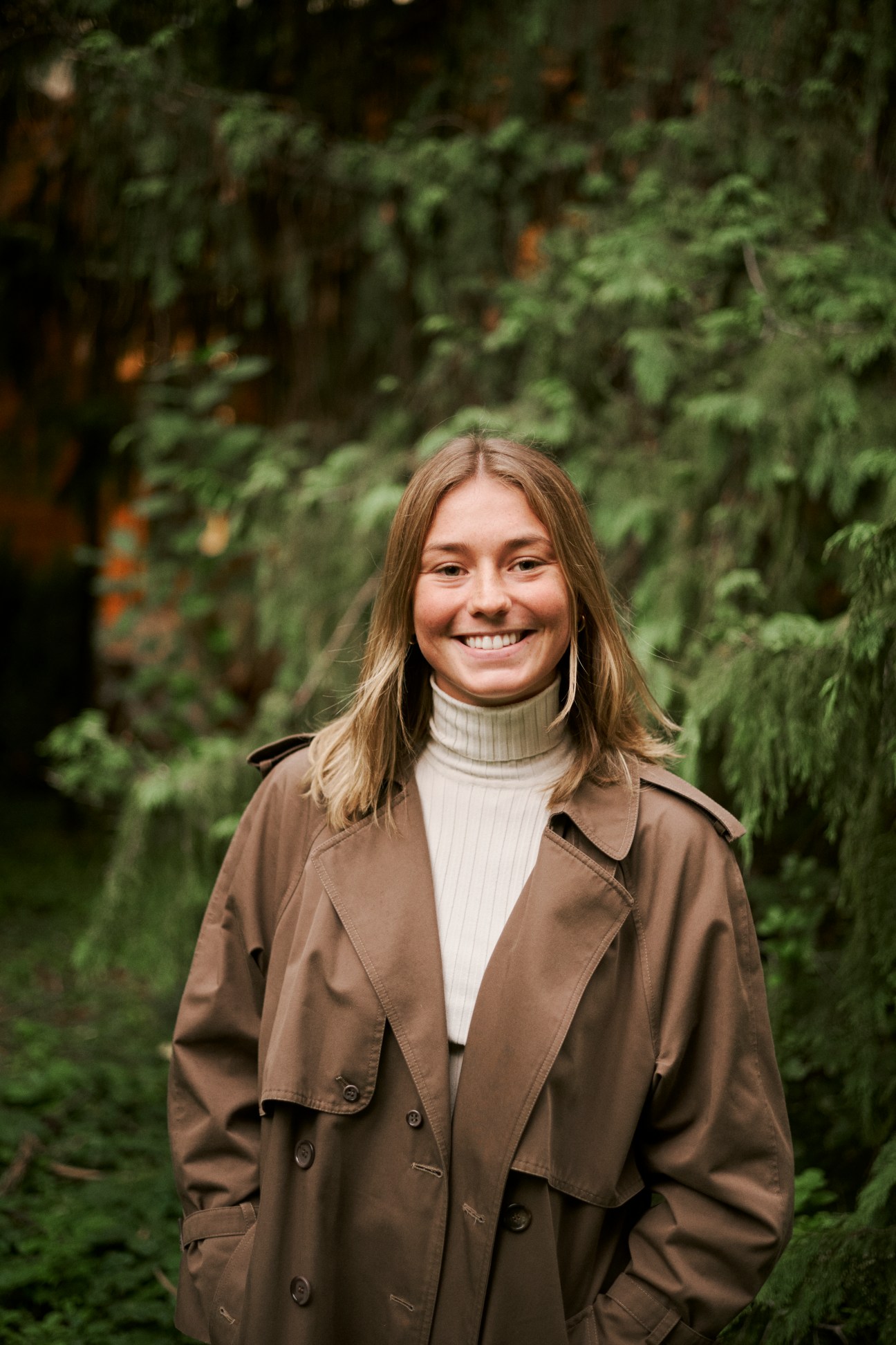 Yseult Besnard, a French student at the Vienna diplomatic academy, smiling outdoors in a brown trench coat