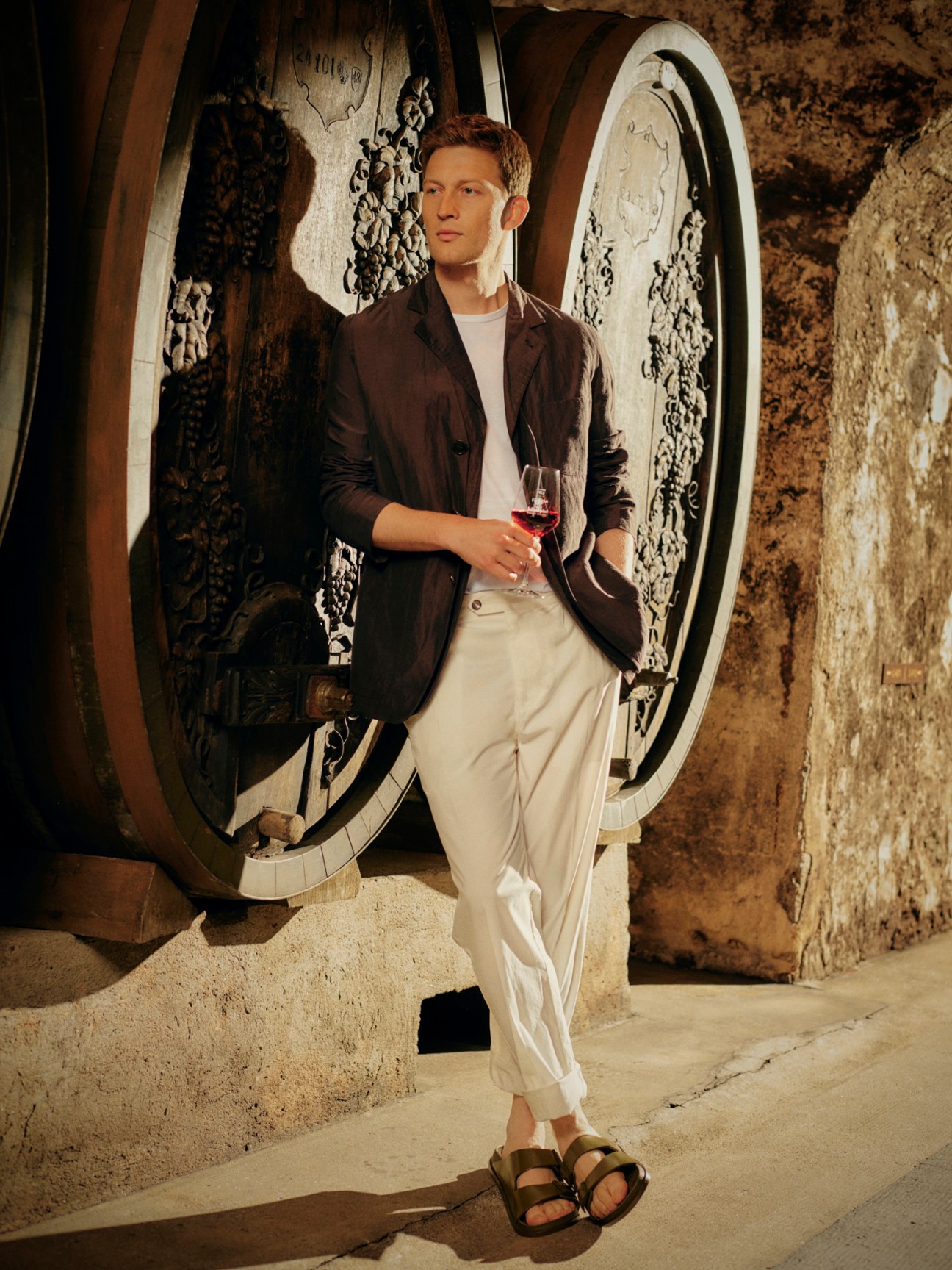 Model in bright gilet and jacket ensemble with casual trousers and sandals