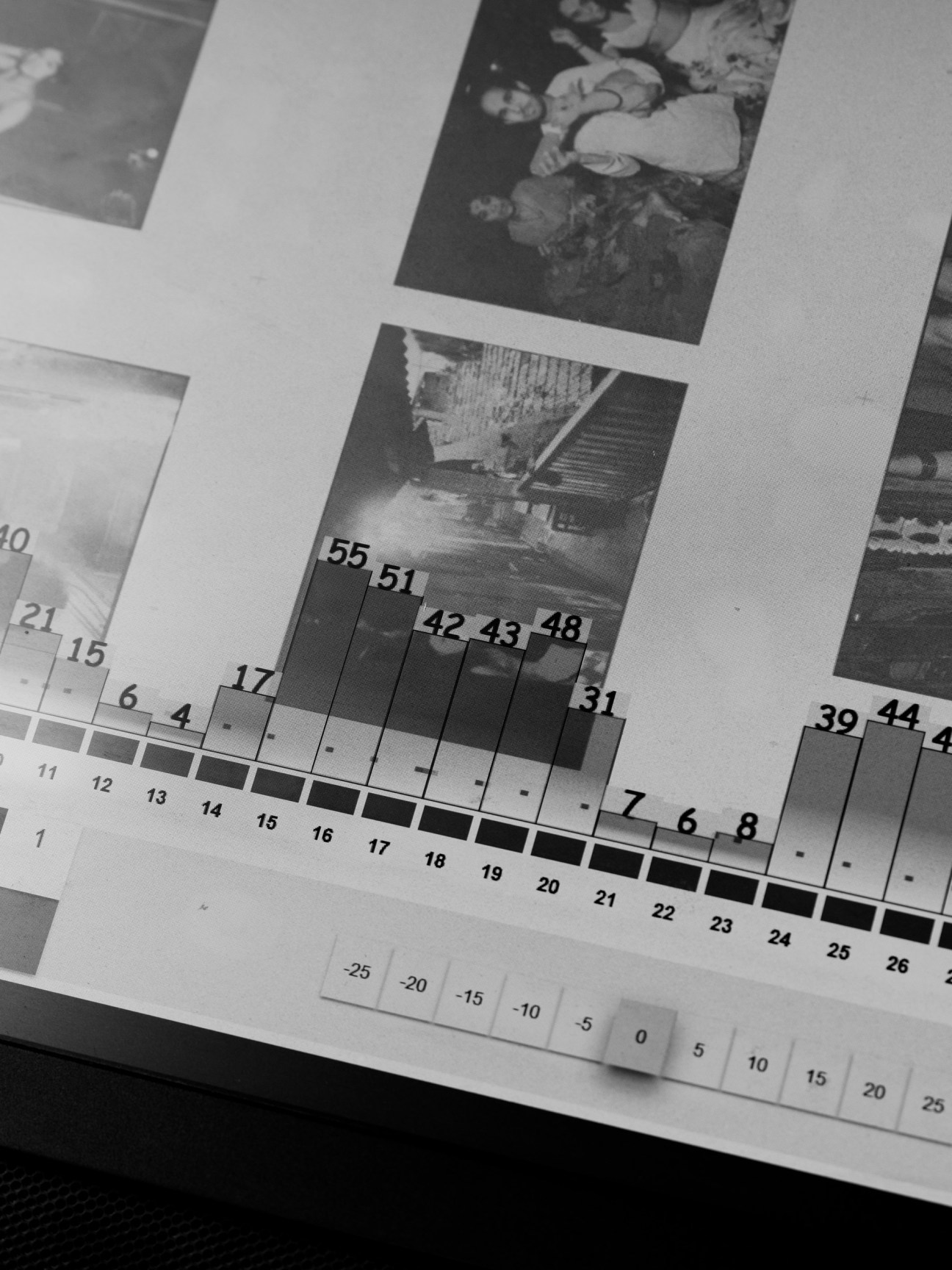 Black and white photograph showing printing proofs with numbered color calibration strips and measurement scales