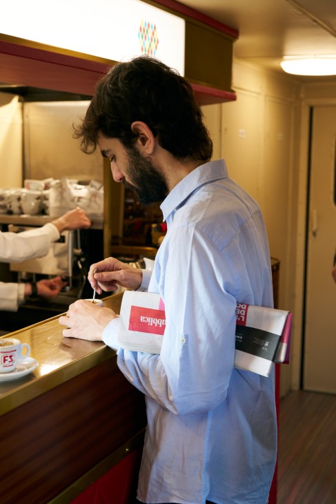 Passengers reading newspapers aboard the L'Arlecchino train