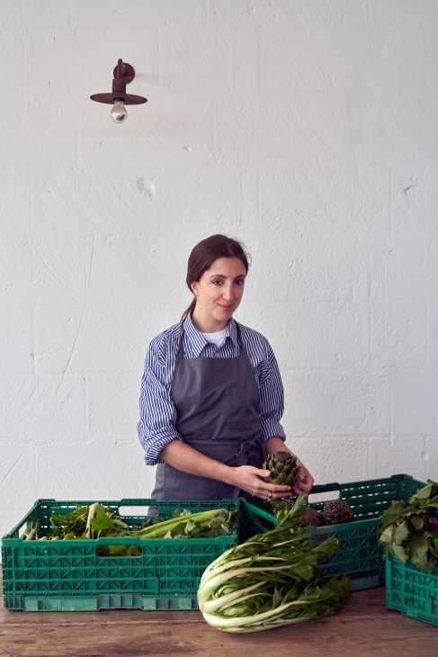 Female chef Giorgia Eugenia Goggi in a modern kitchen preparing dishes