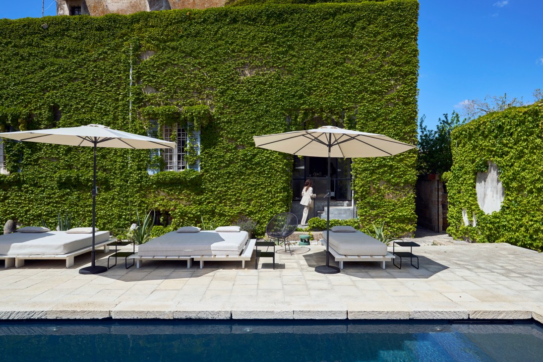 White outdoor loungers beside a swimming pool at a luxury hotel