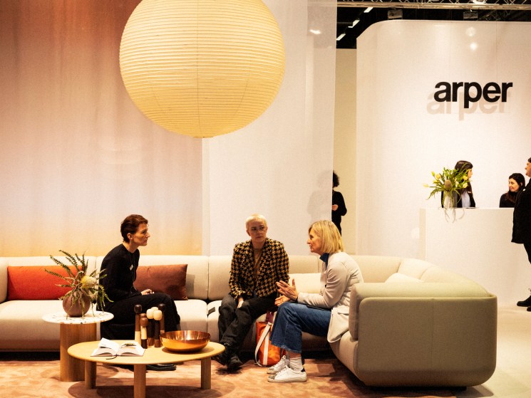 Modern furniture showroom with white sofas, wooden coffee table, large paper lantern and Arper brand signage