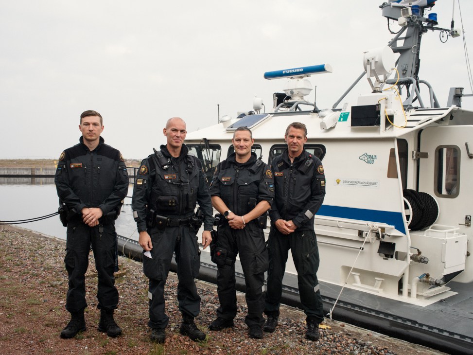 Three border guard officers in uniform standing together outdoors