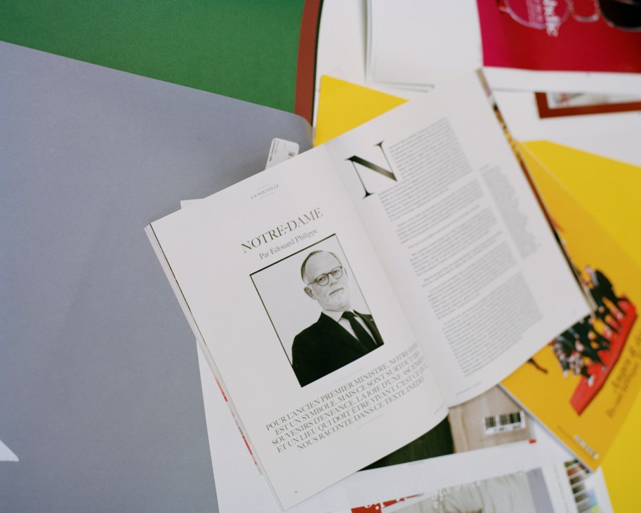 Open magazine spread showing article titled 'Notre-Dame' with portrait photo of man in suit and glasses