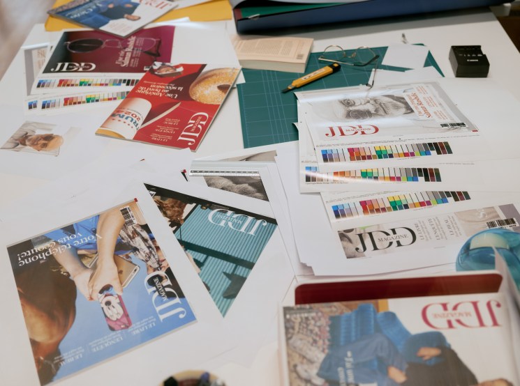 Scattered catalogues and colour swatches on a worktable.