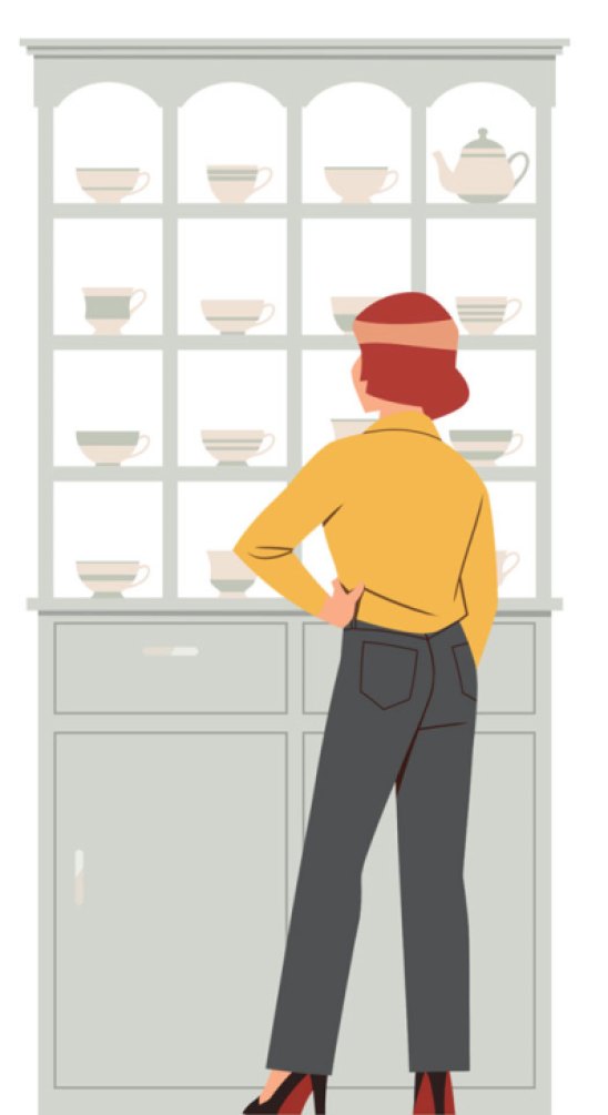 Person in yellow sweater and dark pants standing in front of china cabinet displaying teacups and dishes