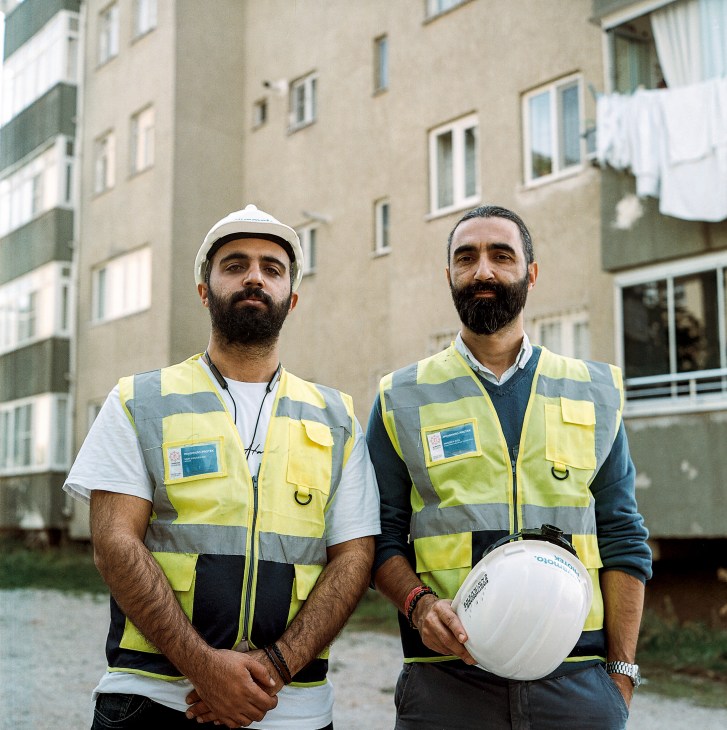 Structural engineers examining damaged building with assessment tools
