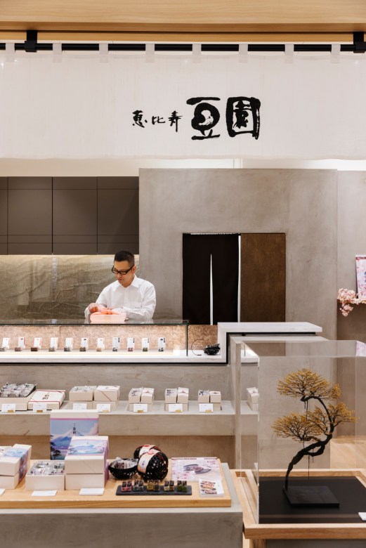 Service counter at Mamezono confectionery shop with staff member and display case