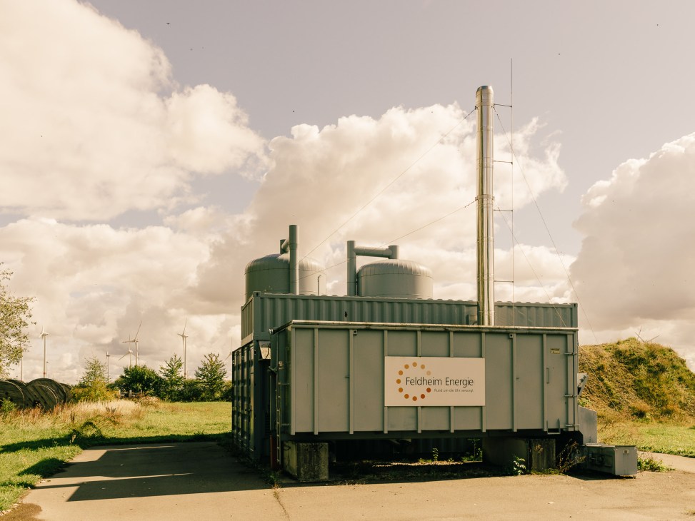 Feldheim Energie facility with green tanks and smokestacks in rural German landscape