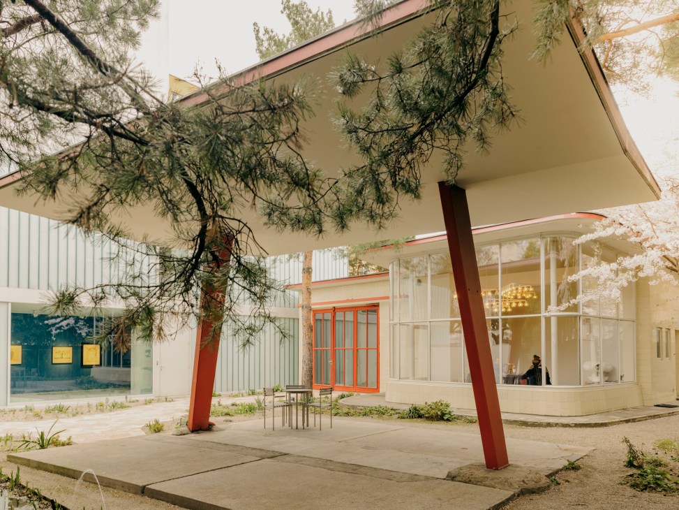 Former petrol station with modernist glass structure and outdoor seating area