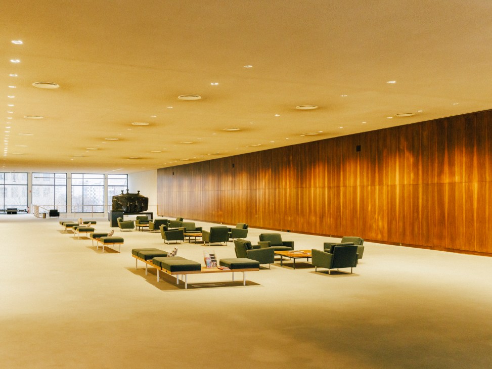 Modern seating arrangement in Deutsche Oper lobby with green chairs and wood-paneled walls