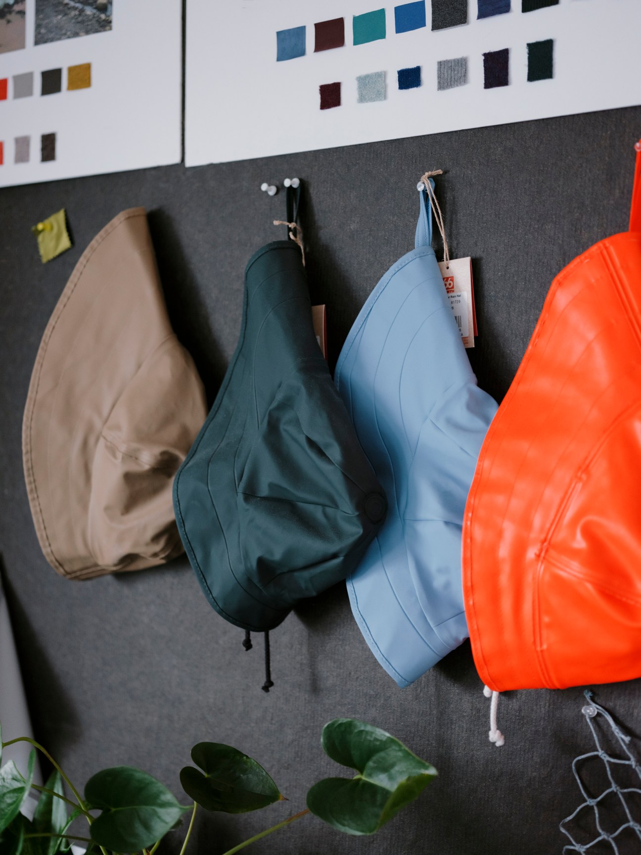 Display of 66°North winter hats and accessories hanging on hooks against a dark wall