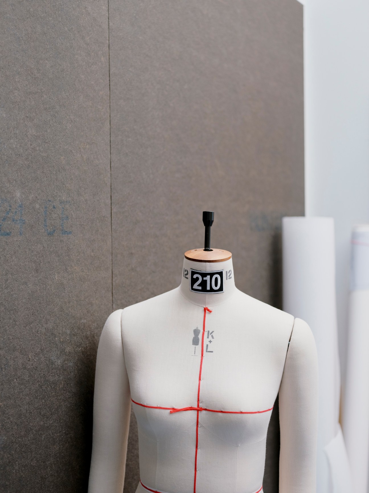 White dress form mannequin numbered 210 with red measurement lines in 66°North showroom