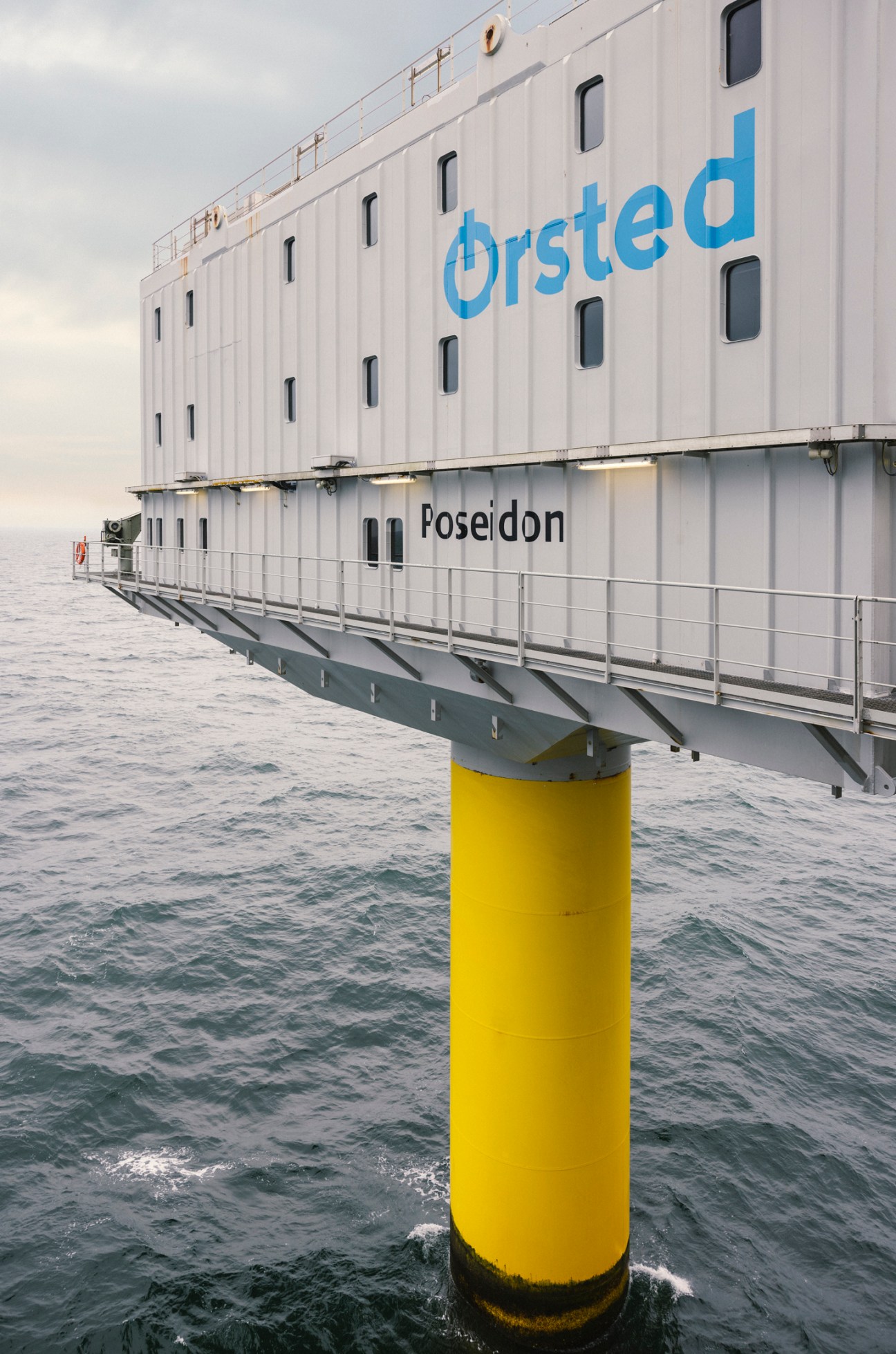Offshore wind facility accommodation platform Poseidon rising from North Sea waters on yellow support pillar