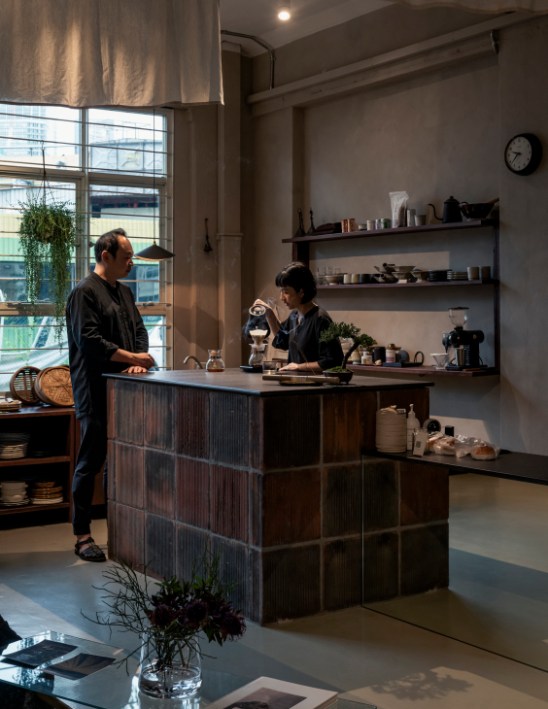 Interior of Asaru Studio boutique featuring bonsais, volcanic rock and steaming bamboo baskets in a minimalist Japanese-inspired setting