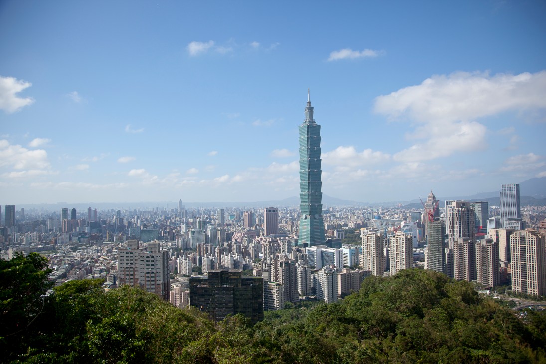 Aerial view of Taipei cityscape with Taipei 101 tower prominently rising above dense urban development