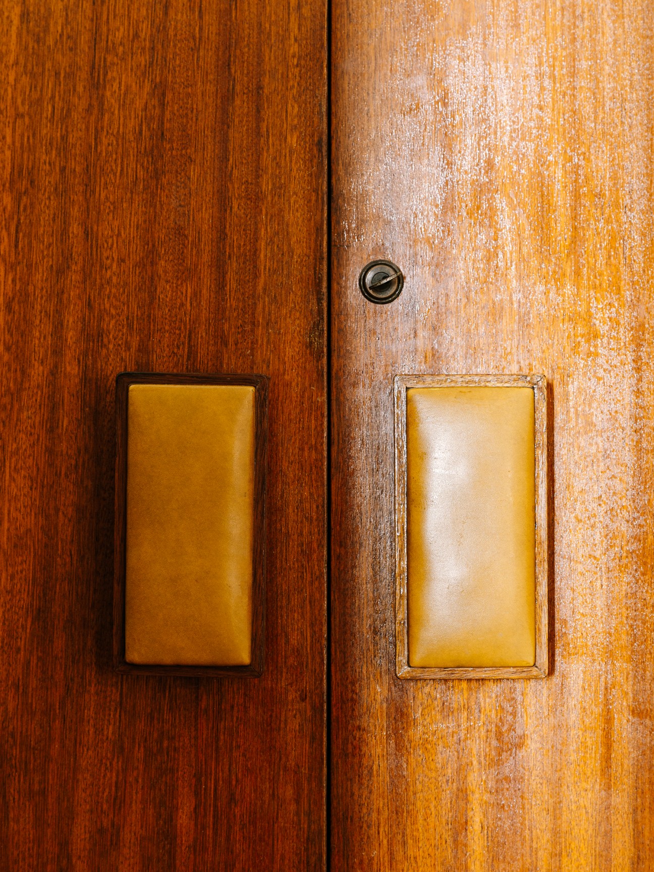 Two wooden cabinet doors with golden-yellow panel inserts, showing weathered wood grain and patina.