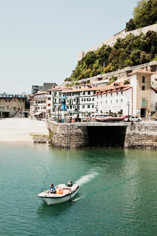 Coastal town with white buildings and small boat in harbor waters