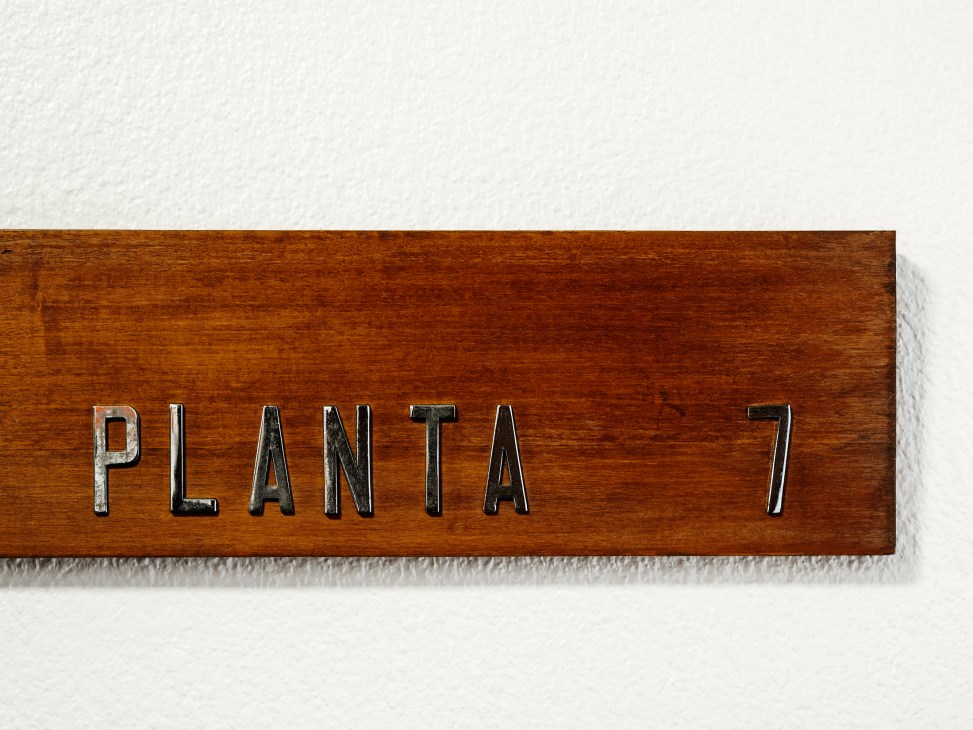 Wooden door signs displaying floor numbers in the building's entrance hallway
