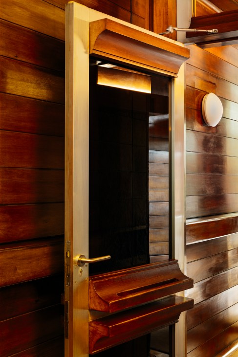 Original curved wooden apartment door reflecting the building's architectural vernacular