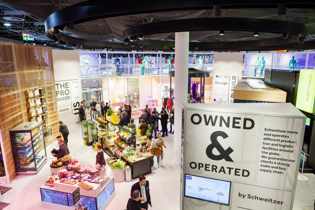 Overhead view of Schweitzer's Circle retail stand at EuroShop with branded signage, product displays, and visitors on multiple levels.