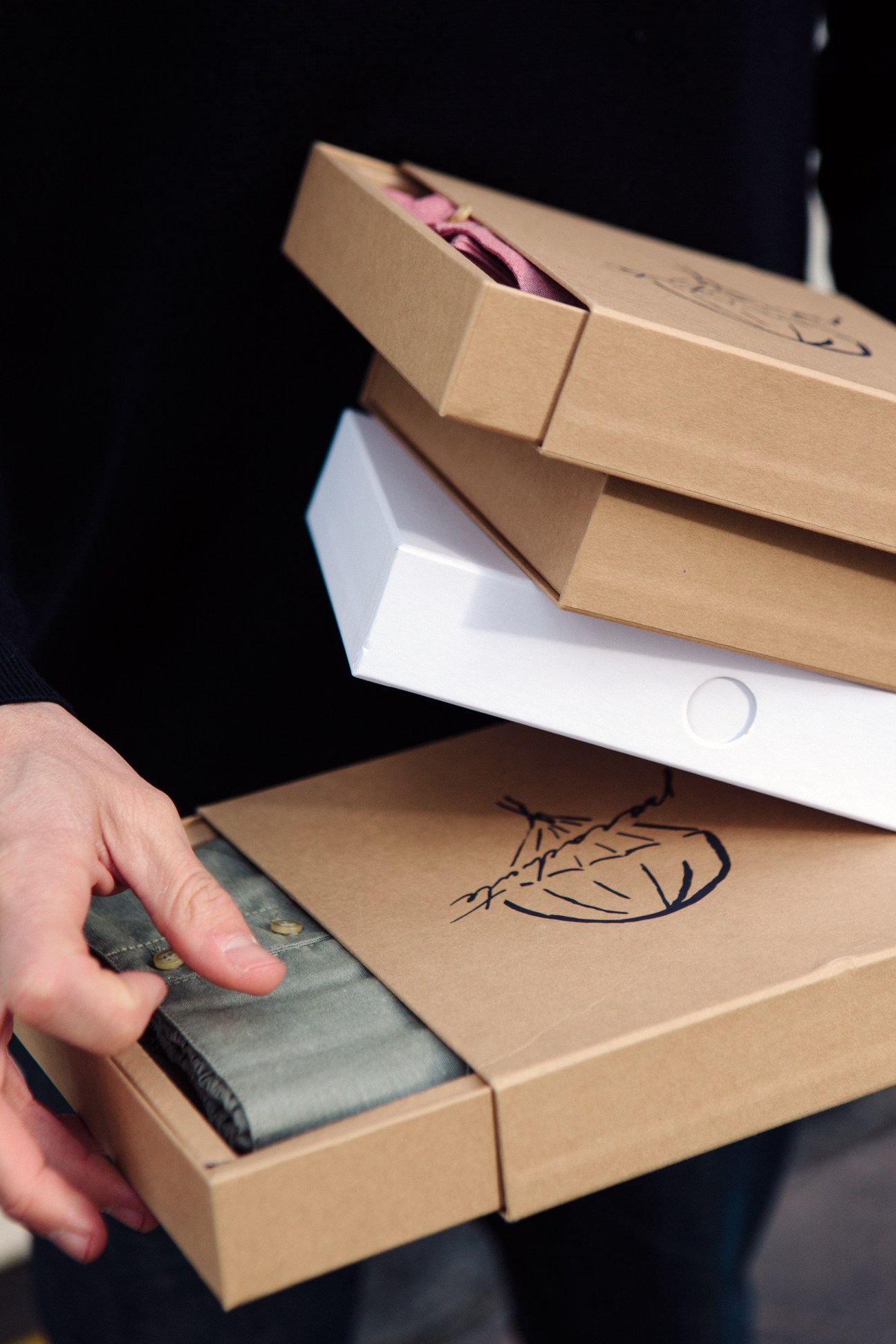 Hand opening cardboard box with Parachute Caleçons branded packaging containing underwear