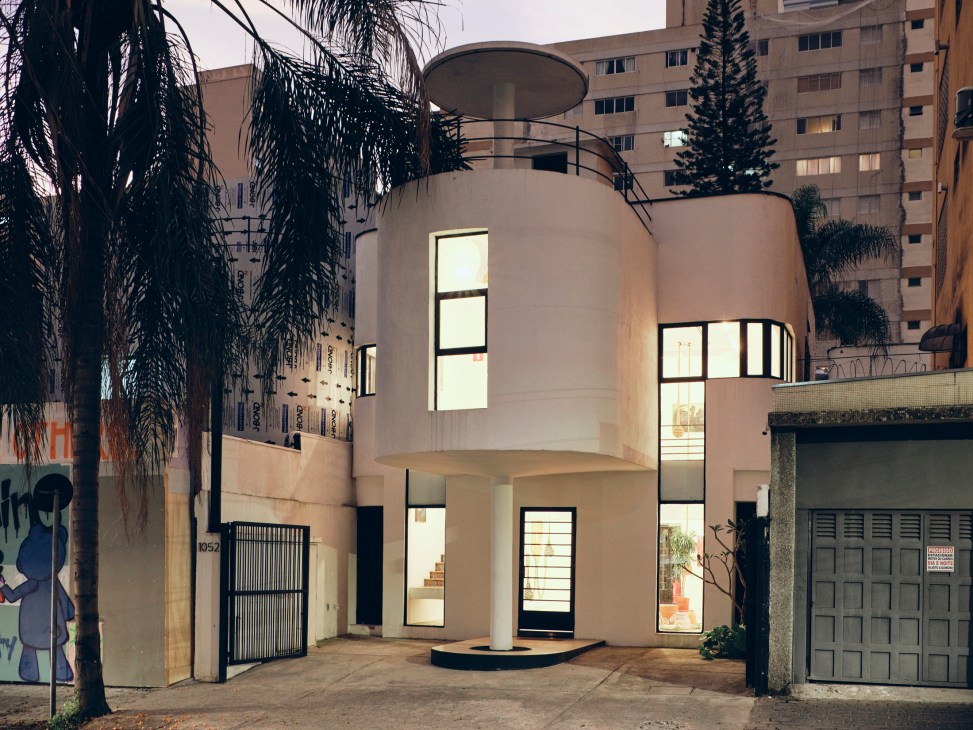 Modernist house with curved white facade and circular rooftop terrace in Vila América, São Paulo