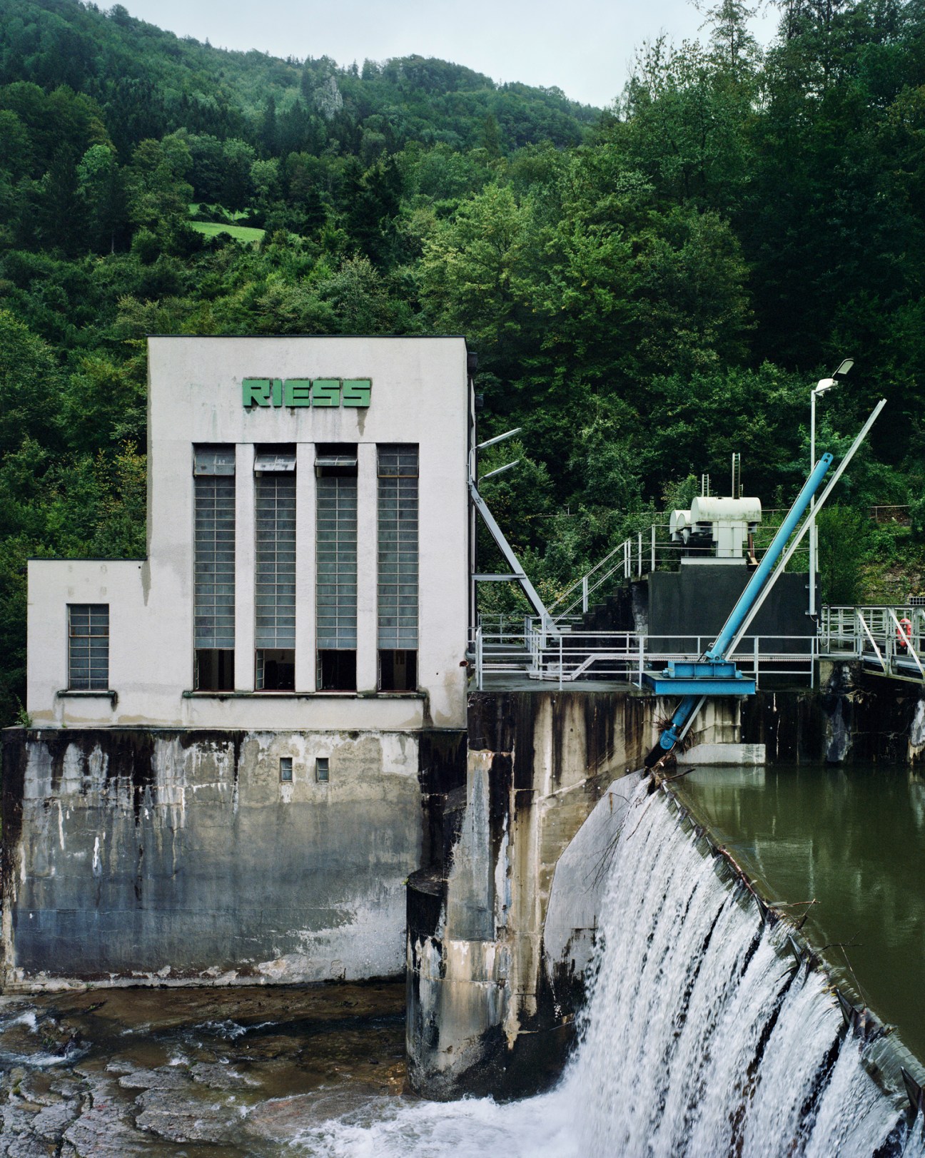Hydroelectric dam with water flowing over concrete spillway structure