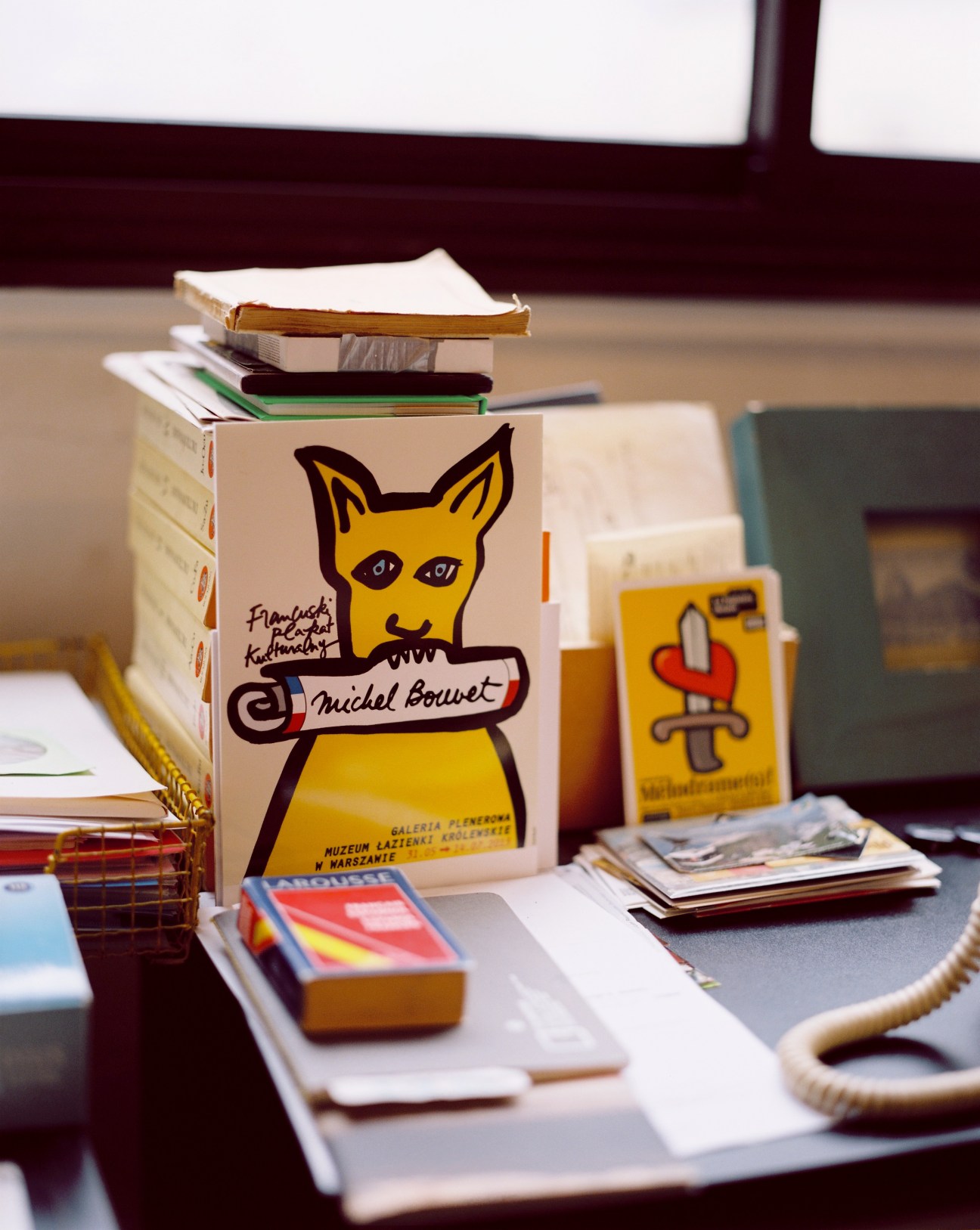 Michel Bouvet's graphic design work and books displayed on a desk, featuring a yellow cat illustration.