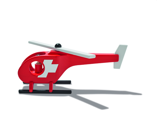 Red wooden toy helicopter with Swiss flag emblem by Schweizer Heimatwerk.