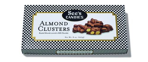 See's Candies Almond Clusters box with chocolate-covered almonds on checkered wrapper.