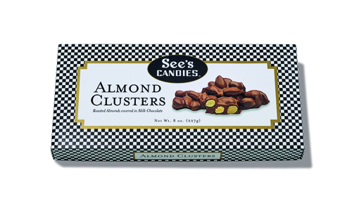 See's Candies Almond Clusters box with chocolate-covered almonds on checkered wrapper.