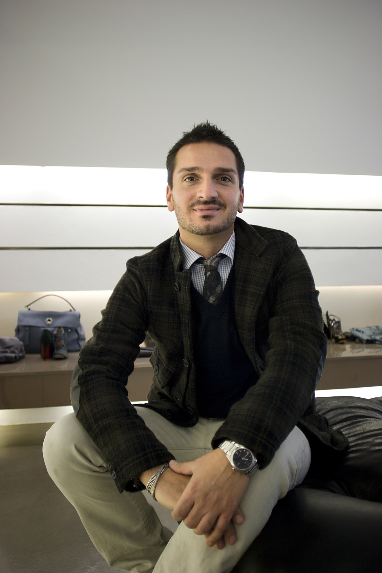 Davide Mattiolo, shoe salesman at Antonia boutique in Milan, seated in the store.