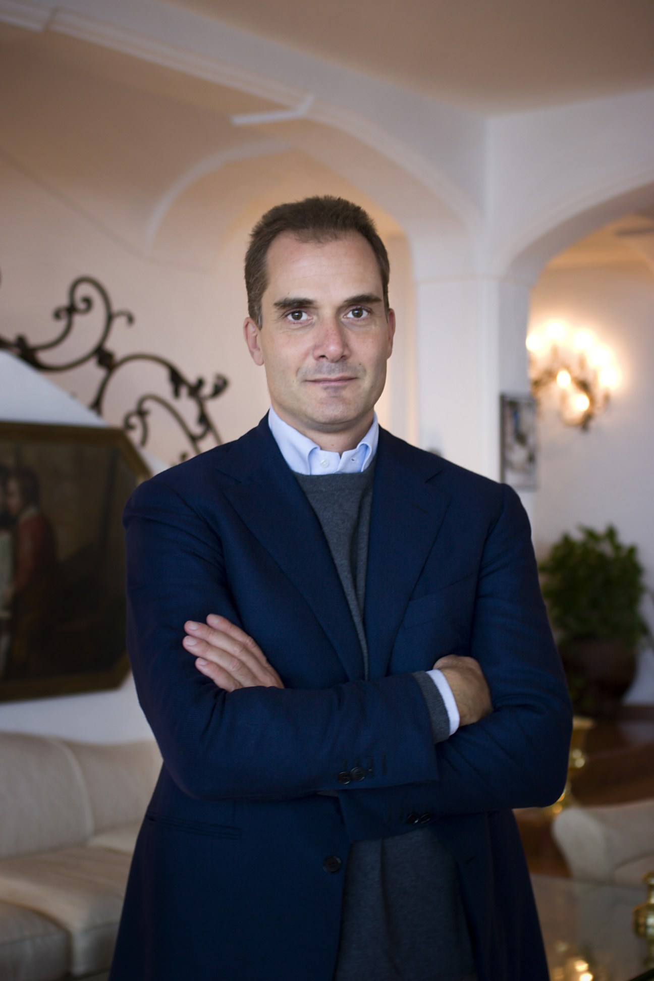 Vito Cinque, general manager of Hotel II San Pietro in Positano, stands with arms crossed in an elegant hotel interior.