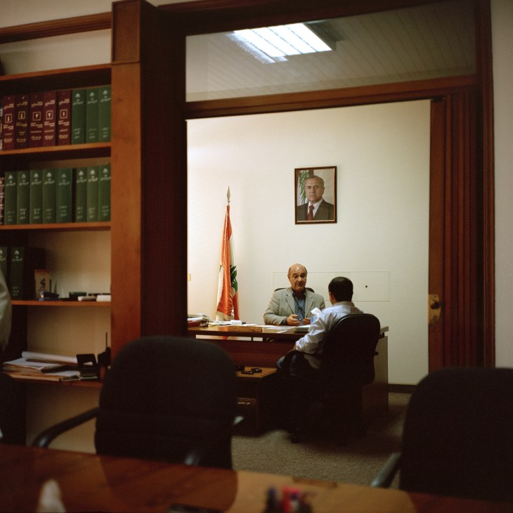 Issam Shammas, Raïs of Rabieh, Lebanon, sits at his desk during a meeting with a visitor in his office.