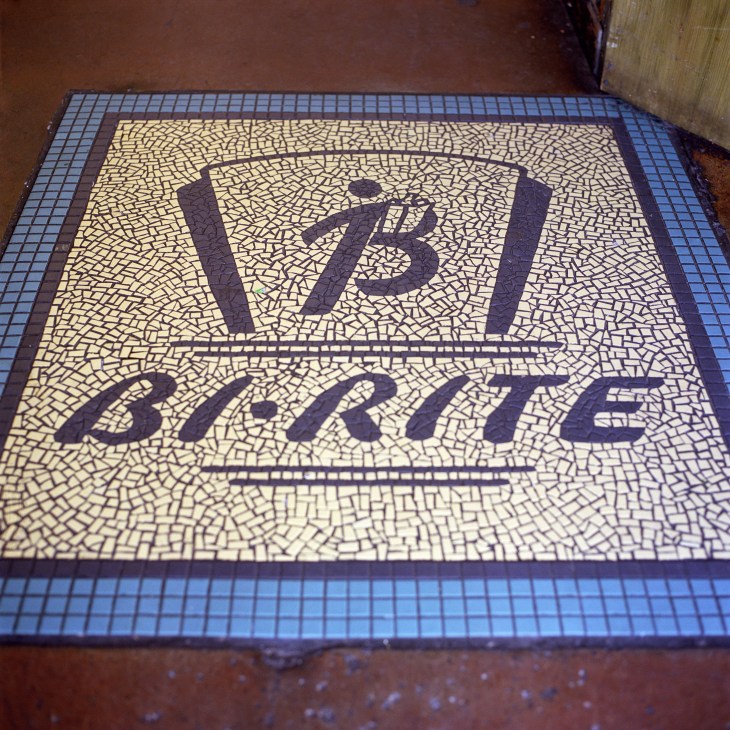 Art Deco tiled floor displaying the Bi-Rite grocery market logo with decorative blue border