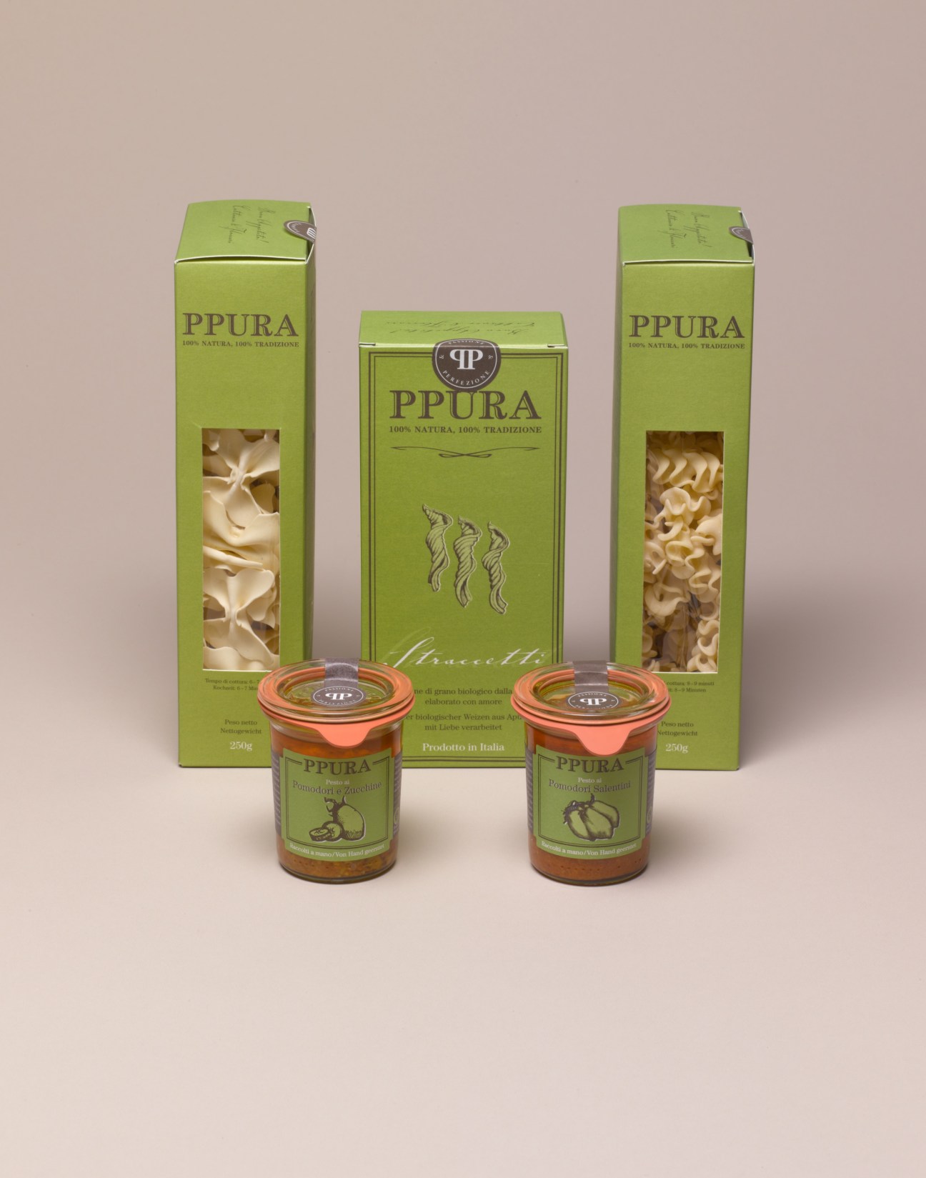 Ppura artisanal pasta boxes and pesto jars in green packaging displayed against a beige background.