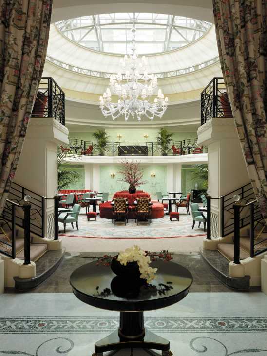 Shangri-La Paris hotel lobby with domed skylight, crystal chandelier, and elegant furnishings.