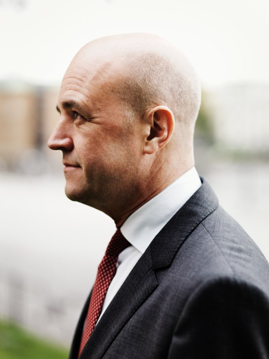 Profile portrait of Fredrik Reinfeldt, Prime minister of Sweden, wearing a dark suit and burgundy tie.