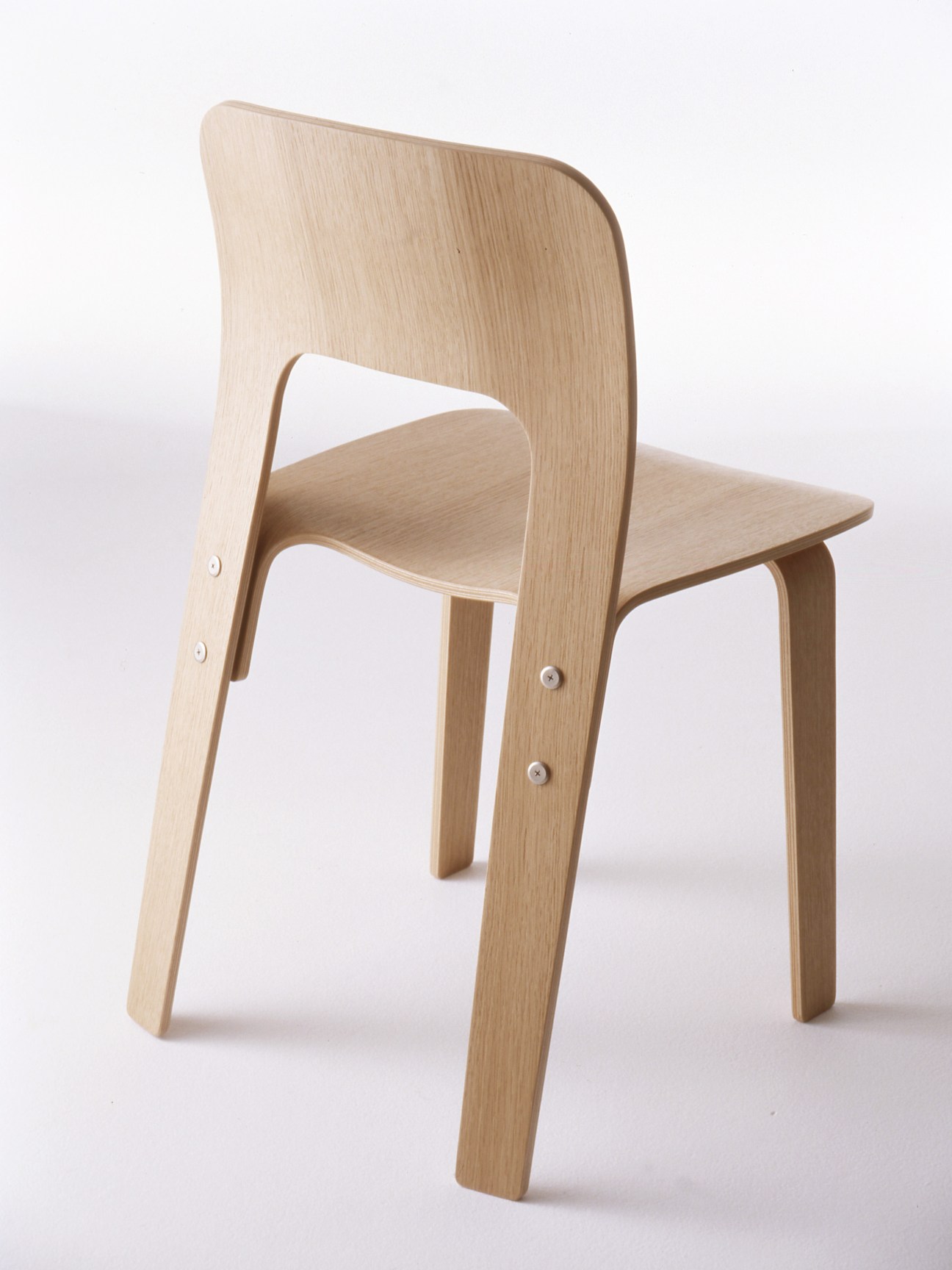 Light wood chair with curved backrest and simple cylindrical legs against white background.