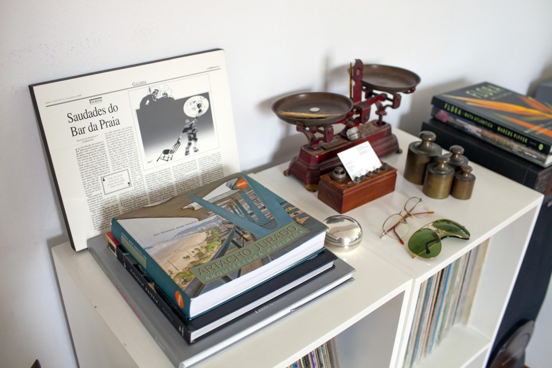 A shelf displaying a book on Artacho Jurado alongside vintage scales, decorative objects, and personal memorabilia.